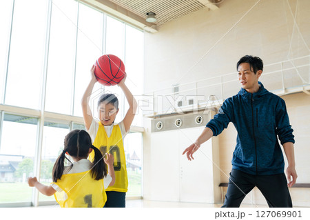 バスケットボールをする子供たちと指導する男性 127069901