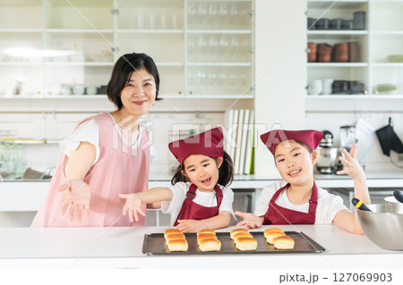 パンを焼く女の子たちと女性 127069903