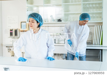 厨房を清掃する衛生白衣を着た男女スタッフ 厨房を清掃する衛生白衣を着た男女スタッフ 127069950