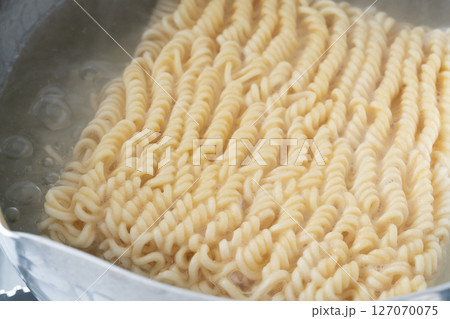 インスタントラーメンを鍋で茹でる インスタントラーメンを鍋で茹でる 127070075