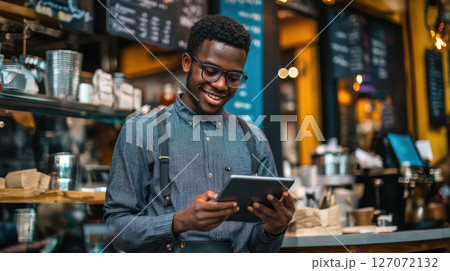 young entrepreneur using tablet in vibrant cafe, engaged in financial services 127072132
