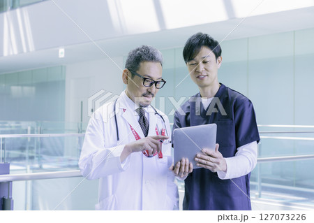 病院でタブレットを見ながら会話する2人の医師のポートレート 撮影協力:スカパー東京メディアセンター 病院でタブレットを見ながら会話する2人の医師のポートレート 撮影協力:スカパー東京メディアセンター 127073226