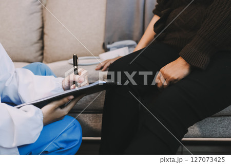 Young doctor examines senior patient's leg Young doctor examines senior patient's leg 127073425