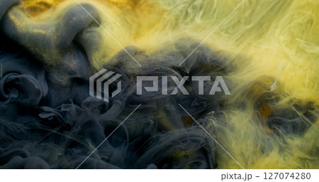 Ink stream. Dye spread. Yellow liquid color paint explosion flow. Art fume wave blend abstract blur black golden glitter background. 127074280