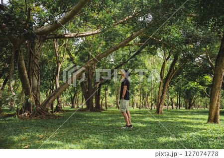wellness concept with asian man exercise with tree in park on summer season wellness concept with asian man exercise with tree in park on summer season 127074778