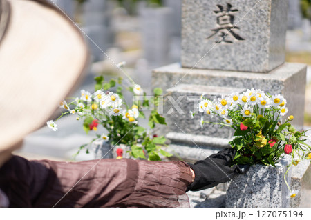 墓前に花を添える女性 127075194