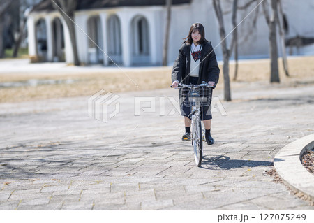 立ち漕ぎする学生 127075249