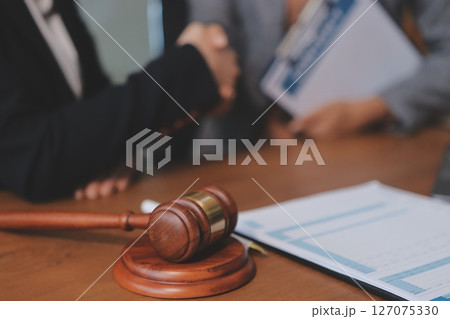 Judge gavel with Justice lawyers having team meeting at law firm background. Concepts of Law and Legal services. 127075330