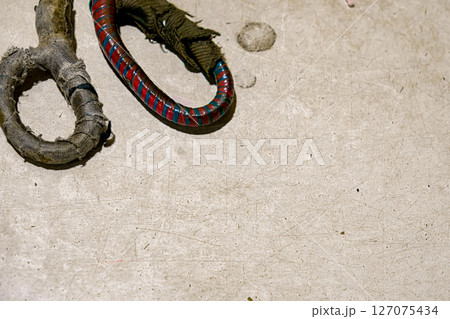 Worn fabric scissor handles on a textured surface 127075434