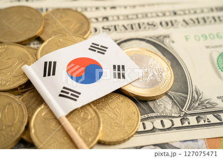 Stack of coins with South Korea flag and US dollar banknotes. 127075471