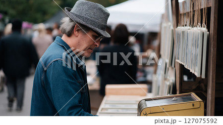 Artist Selling Prints at Weekend Market Booth Engaging with Customers and Displaying Artwork 127075592