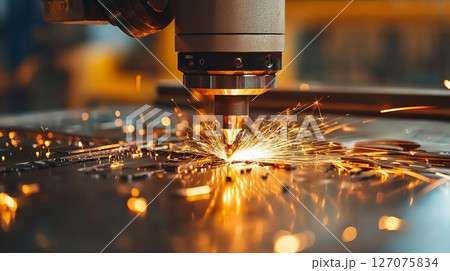 Industrial Laser Cutting Process Creating Sparks on Metal Sheet in Workshop Environment 127075834