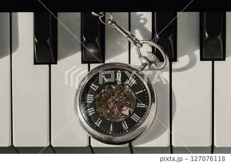 Top view of Antique pocket watch or Retro pocket watch on Piano keys background. 127076118