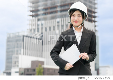 スーツにヘルメット被ってタブレットをもつ若い女性 施工管理者 現場監督 土木女子(ドボジョ) スーツにヘルメット被ってタブレットをもつ若い女性 施工管理者 現場監督 土木女子(ドボジョ) 127077399