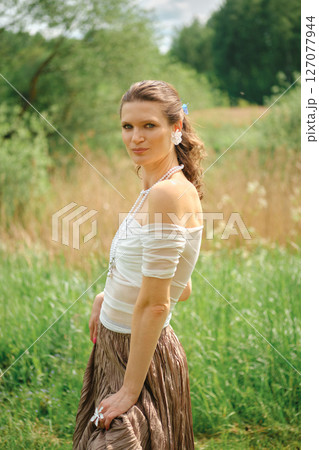 Woman in outdoor setting wearing casual clothing and accessories during a sunny day 127077944