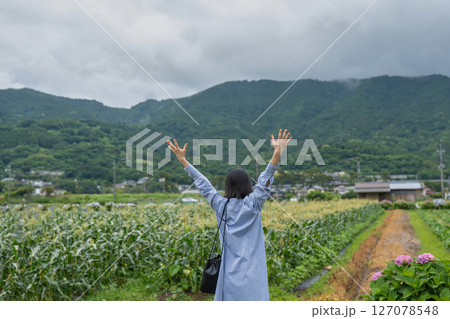 田園風景を見てリラックスする女性の後ろ姿 127078548