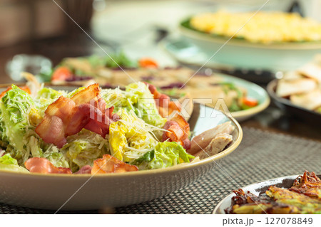 Salad with grilled bacon, hard cheese, tomato, and croutons. 127078849