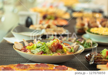 Salad with grilled bacon, hard cheese, tomato, and croutons. 127078850