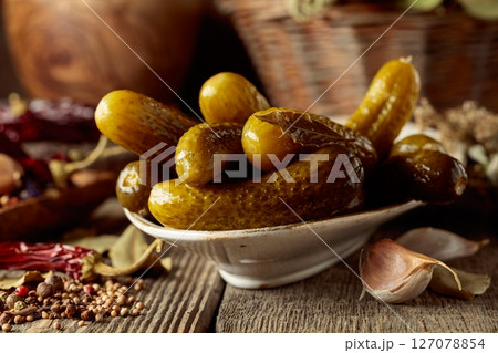 Pickled cucumbers with ingredients on an old wooden table. Pickled cucumbers with ingredients on an old wooden table. 127078854