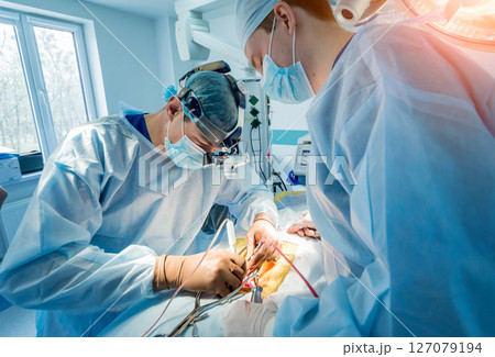 Spinal surgery. Group of surgeons in operating room with surgery equipment.  127079194