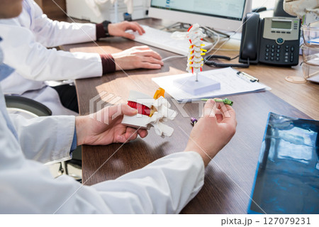 Doctor show polyaxial screw on the spine model. Spine fixation systems Doctor show polyaxial screw on the spine model. Spine fixation systems 127079231