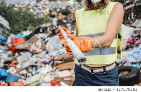Woman volunteer helps clean the field of plastic garbage. Woman volunteer helps clean the field of plastic garbage. 127079263