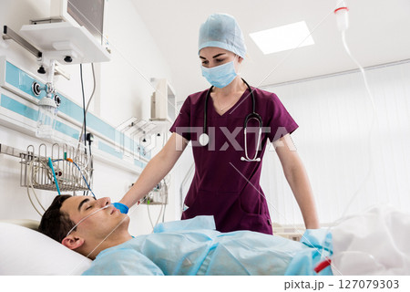 Doctors give resuscitation to a male patient in the emergency room. 127079303