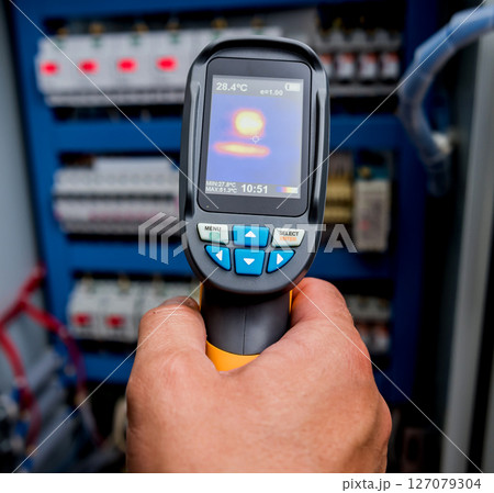 Technician use infrared thermal imaging camera to check temperature at fuse-box Technician use infrared thermal imaging camera to check temperature at fuse-box 127079304