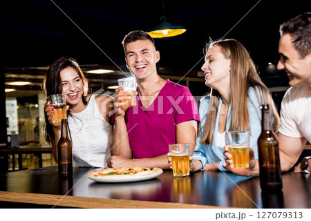 Cheerful friends in the pub. Drinking beer, wine and whisky 127079313