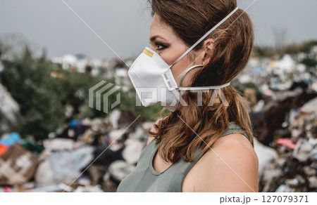 Woman volunteer helps clean the field of plastic garbage. Woman volunteer helps clean the field of plastic garbage. 127079371