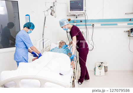 Doctors give resuscitation to a male patient in the emergency room. 127079586