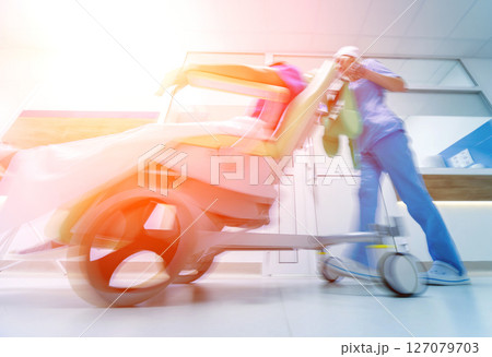 Nurse moves mobile medical chair with patient at hospital. Medical equipment. Nurse moves mobile medical chair with patient at hospital. Medical equipment. 127079703