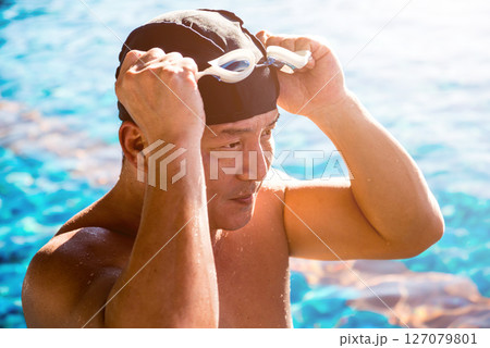 Young athletic man swimming in the swimming pool 127079801