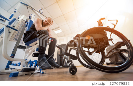 Disabled man doing strength exercises separate from the wheelchair. Disabled man doing strength exercises separate from the wheelchair. 127079832