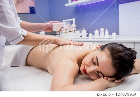 Beautiful young woman enjoying massage in spa salon. Cosmetology Beautiful young woman enjoying massage in spa salon. Cosmetology 127079914