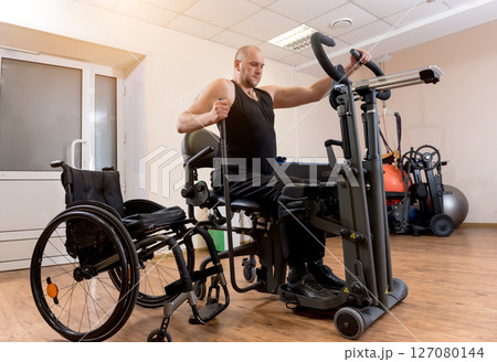 Disabled man training in the gym. Rehabilitation center 127080144
