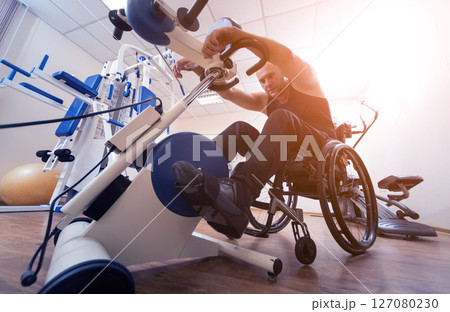 Disabled man training in the gym. Rehabilitation center Disabled man training in the gym. Rehabilitation center 127080230