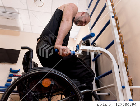 Disabled man training in the gym. Rehabilitation center Disabled man training in the gym. Rehabilitation center 127080394