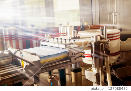 Automatic labeling machine during operation. Factory for the production Automatic labeling machine during operation. Factory for the production 127080482