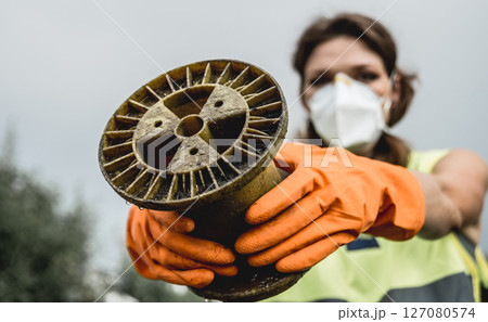 Woman volunteer helps clean the field of nuclear waste and plastic garbage.  127080574