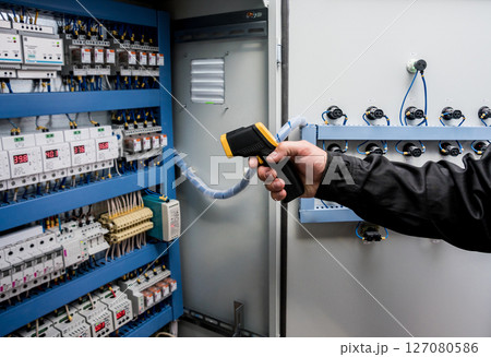 Technician use infrared thermal imaging camera to check temperature at fuse-box 127080586