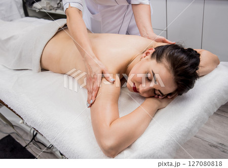 Beautiful young woman enjoying massage in spa salon. Cosmetology Beautiful young woman enjoying massage in spa salon. Cosmetology 127080818