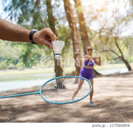 A man and a young woman are playing badminton together in a park 127080869