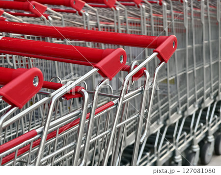 A row of shopping carts is neatly lined up in a straight row A row of shopping carts is neatly lined up in a straight row 127081080