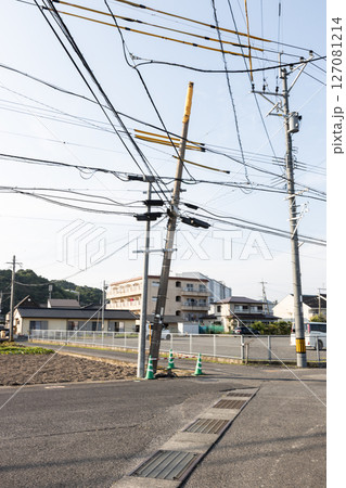 傾いた電柱を補強している素材写真　たくさんの電線が交差しあっている 127081214