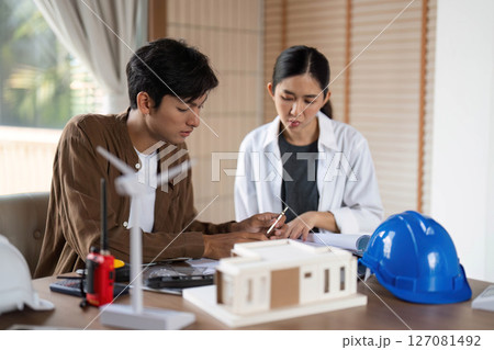 ESG Principles in Action. Young architects collaborating on sustainable building designs. 127081492