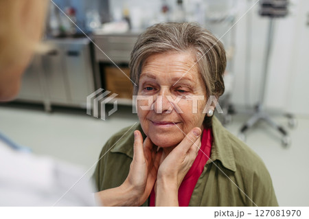 Doctor palpating lymph nodes during medical examination of senior patient. 127081970