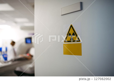 CT scan in progress behind radiation warning sign 127082002