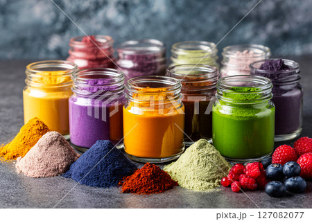 assorted superfood powder jars with vibrant smoothie shots 127082077