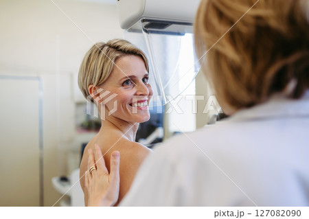 Healthcare professional adjusts the patient for accurate breast imaging. 127082090